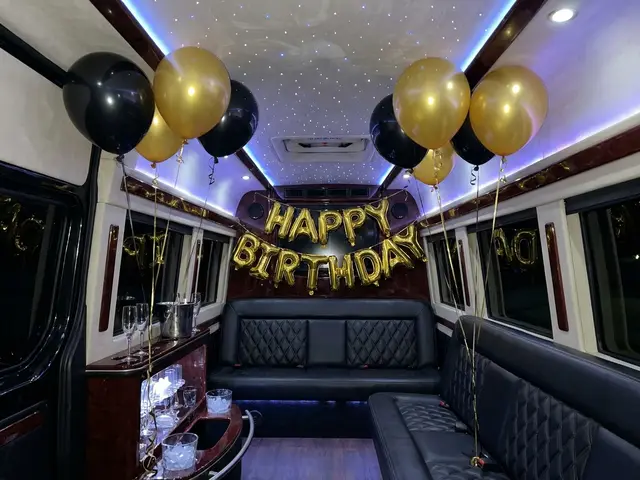 Party bus decorated with balloons and a birthday banner
