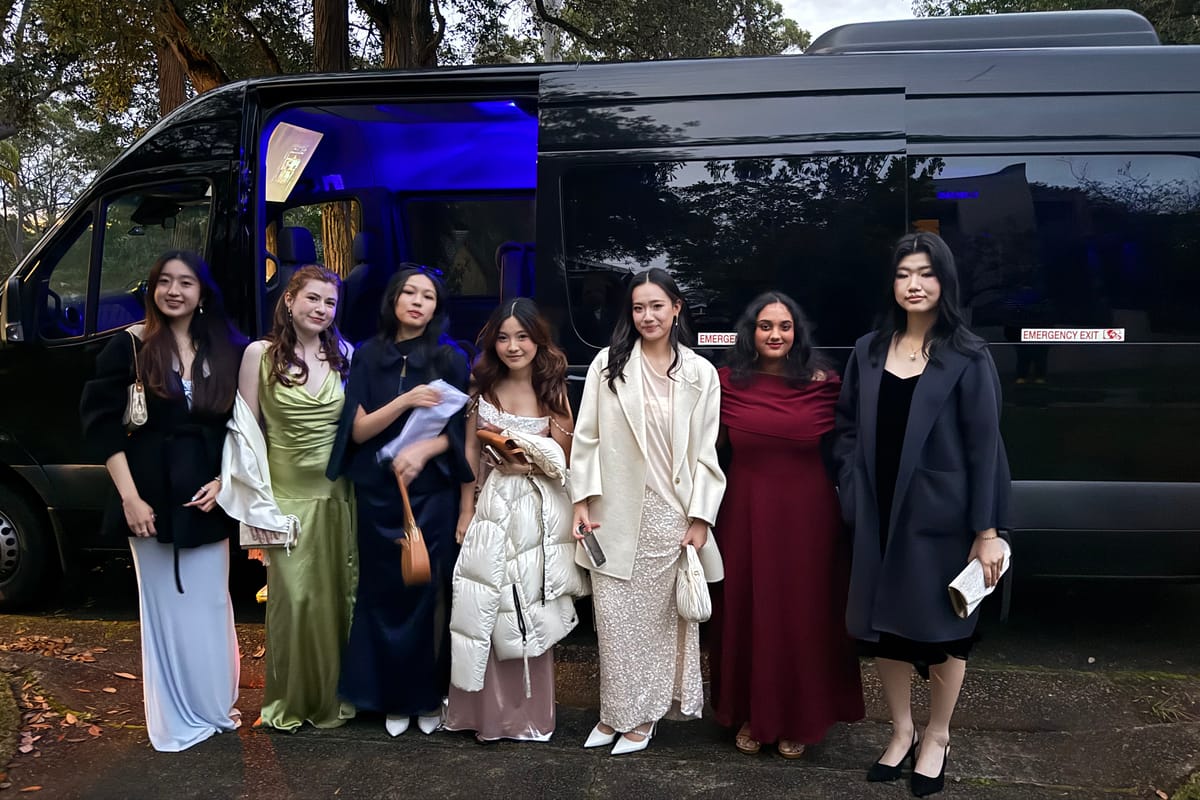 Guests dressed for a formal in front of the Sprinter party bus